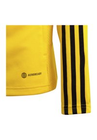 Geel sportshirt van textiel, met een zwarte driekleurige strepenpatroon op de mouwen en het AEROREADY-logo nabij de zoom.