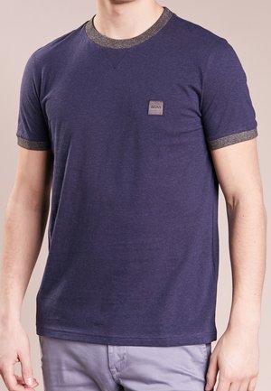 Man wearing a navy blue short-sleeve T-shirt with gray trim on collar and sleeves, and a small "BOSS" logo on the chest.