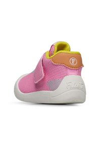 Rosa Netzschuh mit einer weißen Gummisohle, Klettverschluss und einem kontrastierenden gelben Knöchelkragen. Mit einem Logo auf der Rückenschlaufe.