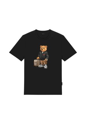Maglietta nera con una grafica di un orso che indossa una giacca nera, orologio, sneakers e trascina una valigia beige con ruote.