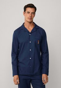 Camisón de manga larga en azul marino de tejido suave, con un bolsillo en el pecho con detalle bordado y botones blancos en el frente.
