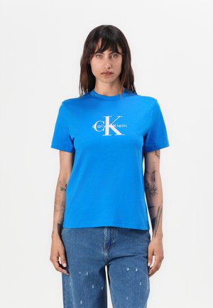 Kortekrullende blauwe katoenen T-shirt met een wit Calvin Klein-logo in het midden. Ronde hals, relaxte pasvorm, gladde textuur.