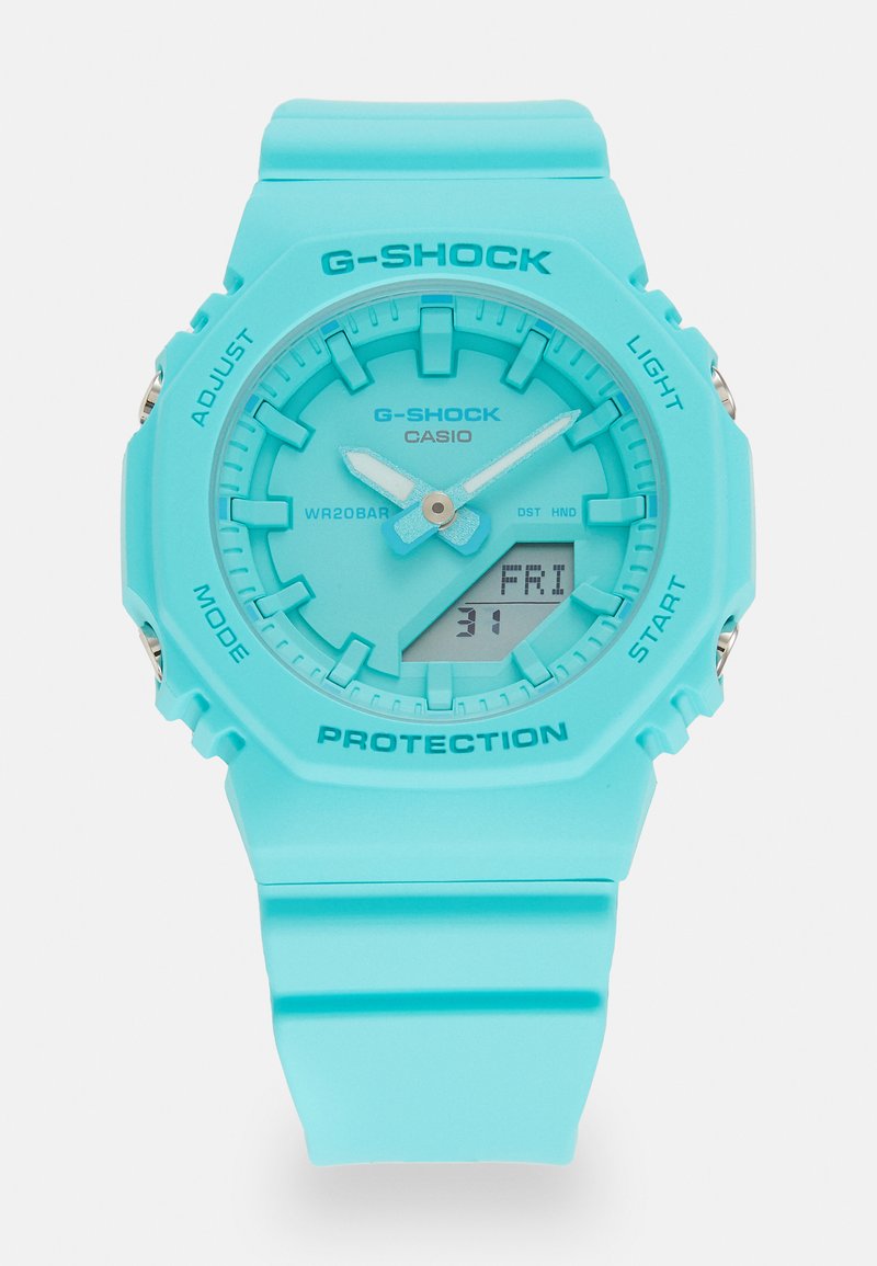 Turquoise G-SHOCK watch with a matte finish, a round digital-analog face, textured buttons, and a rubber strap; rated WR 20 BAR.