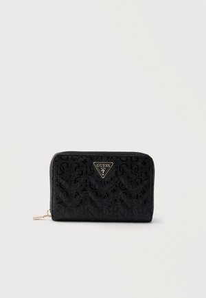 Portefeuille noir à fermeture éclair avec motif logo GUESS embossé et emblème triangulaire doré de la marque au centre devant.