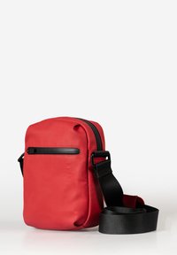 Borsa a tracolla rossa con texture liscia, dettagli in cerniera nera e tracolla nera regolabile. Forma rettangolare compatta, design minimale.