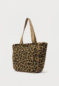 Geantă tip tote cu țesătură de leopard în nuanțe de brun și negru, curele bej și detalii de piping pe părțile laterale, pe un fundal simplu și luminos.