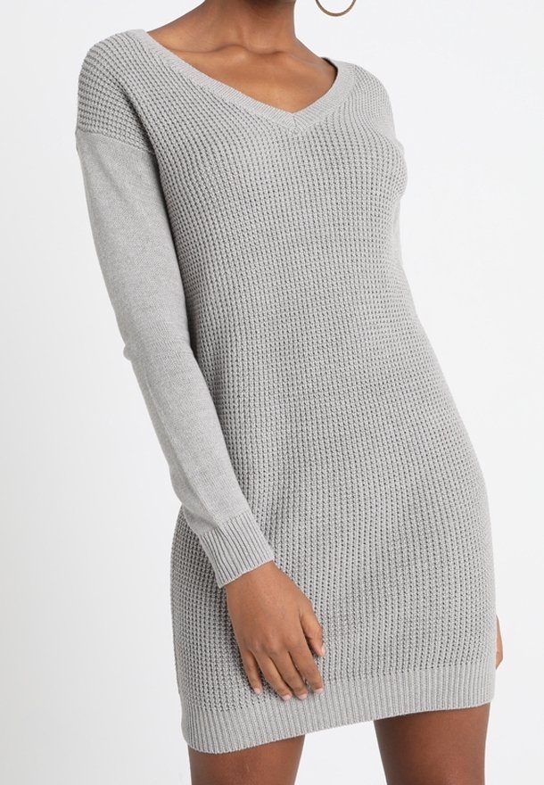 Robe en tricot gris clair. Encolure en V, manches longues à texture côtelée et silhouette ajustée. Tissu doux et extensible.