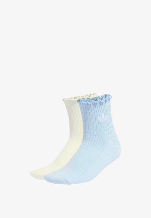 Chaussettes de cheville côtelées en bleu clair et blanc, dotées d'un ourlet froncé et d'un petit logo de couleurs contrastées sur chaque chaussette.
