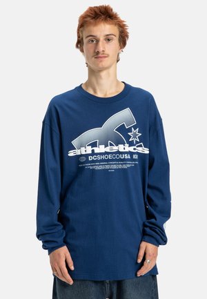 Marineblauwe lange mouw t-shirt van katoen, met een groot wit logo en tekst op de voorkant, voorzien van een klassieke ronde kraag en een comfortabele pasvorm.