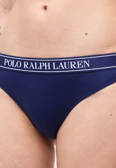 Σκούρα μπλε εσώρουχα με λευκή μέση "Polo Ralph Lauren" που φοριούνται στη χαμηλή κοιλιακή χώρα και τους γοφούς ενός ατόμου.