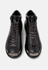 Black leather high-top sneakers featuring brown laces, contrasting stitching, and a rounded toe. The design includes padded ankle support.