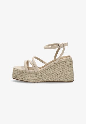 Sandalias de cuña beige con tres tiras delgadas y una correa de tobillo ajustable. La base envuelta en yute presenta un patrón texturizado y tejido.