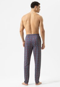 Marineblauwe pyjamabroek met een volledig geometrisch patroon in rood en wit, voorzien van een elastische tailleband en een slank ontwerp van de pijpen.