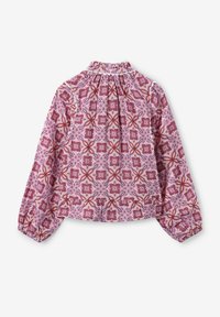 Langärmlige Bluse aus hellrosa Stoff mit einem floralen geometrischen Muster in Rot und Lila, mit einem gerafften Ausschnitt und Ballonärmeln.
