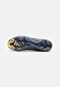 Suola nera delle scarpe da calcio con un motivo testurizzato blu, tacchetti traslucidi e dettagli dorati, progettata per offrire trazione sul campo.