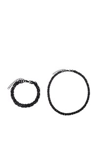 Set di accessori neri composto da un braccialetto testurizzato e una collana abbinata. Entrambi presentano design intrecciati e chiusure regolabili.