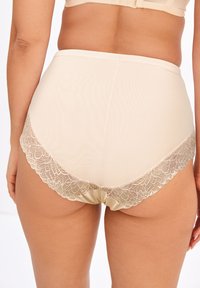 Culotte alte color beige con bordi in pizzo, dal corpo liscio e opaco, con delicate rifiniture in pizzo floreale lungo i bordi inferiori.