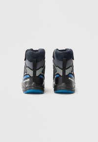 Chaussures de randonnée montantes avec une tige en mesh noir, des accents gris, des détails bleus, un col rembourré et des semelles en caoutchouc texturé. Équipées de languettes de traction.