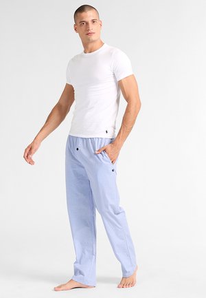 Weiße enganliegende T-Shirt und hellblaue Schlafanzughosen mit einem gestreiften Muster, ausgestattet mit einem elastischen Bund und zwei frontalen Taschen.