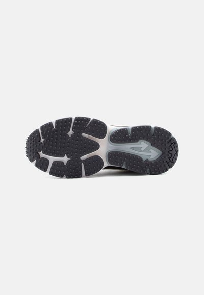 Μαύρη και γκρι ελαστική σόλα με υφή για καλύτερη πρόσφυση και σχέδιο σε σχήμα βέλους στο κέντρο, απεικονιζόμενη πάνω σε απλό λευκό φόντο.