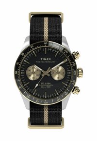 Timex Waterbury watch with a black dial, gold accents, chronograph features, and a black fabric strap with a vertical gold stripe.
