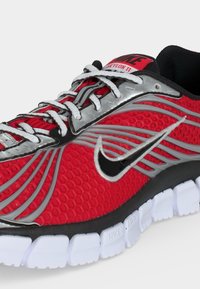 Κόκκινο και ασημί αθλητικό παπούτσι Nike Skylon 11 με λευκά κορδόνια, μαύρο λογότυπο swoosh και λευκή τμηματοποιημένη σόλα.