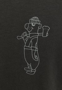 Tejido negro con una superficie texturizada que presenta a un personaje de dibujos animados en overoles sosteniendo un pincel y un cubo, diseño detallado y juguetón.