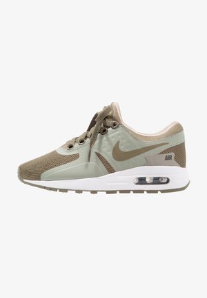Seitenansicht eines beigen und hellgrünen Nike Air Sneakers mit Mesh- und synthetischem Obermaterial, weißer Zwischensohle und sichtbarer Luftdämpfung in der Ferse.