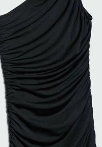 Robe noire avec texture plissée, mettant en valeur un tissu doux, une silhouette ajustée et un détail froncé sur un côté.