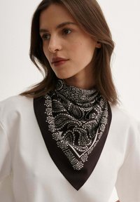 Czarna i biała bandana w wzór paisley, wykonana z miękkiego materiału, stylizowana w kształcie trójkąta, noszona na szyi.