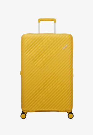 Valigia rigida gialla brillante con scanalature diagonali, manico telescopico e quattro ruote girevoli per una facile manovrabilità.
