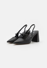 Mustat slingback-korkokengät, joissa on terävät varpaat, valmistettu nahasta, varustettuna lohkokannalla, säädettävällä hihnalla ja minimalistisella muotoilulla.