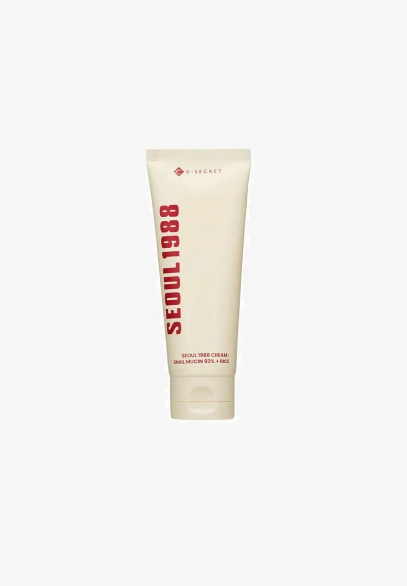 Tube de crème K-Secret Seoul 1988 avec mucine d’escargot à 93 % et riz, emballage beige, texte vertical rouge et bouchon à clapet.