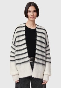 Gebreide cardigan met zwart-witte strepen, gemaakt van een zacht materiaal, met een open voorkant, verlaagde schouders en oversized mouwen.