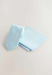 Light blue tie and pocket square set made of textured fabric, featuring a small geometric pattern and smooth edges.