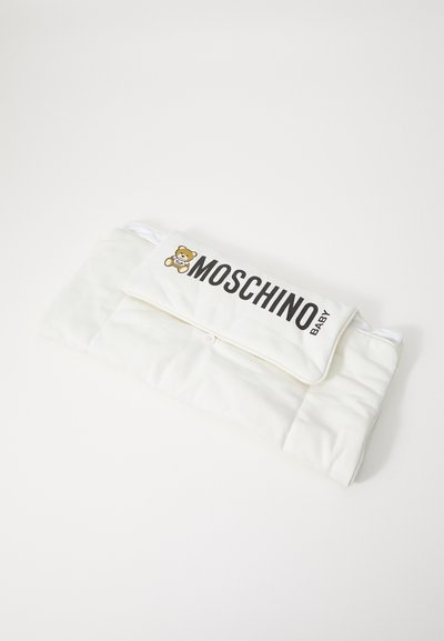 White padded blanket with a fold-over flap featuring a teddy bear graphic and "MOSCHINO BABY" text in black. Soft texture, button closure.
