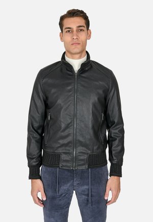 Giubbotto di pelle nera con colletto rialzato, chiusura con zip, dettagli in maglia texture su polsini e orlo inferiore, e tasche laterali.