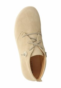 Stivale alla caviglia in suede beige con punta tonda, design con lacci e dettaglio a nodo decorativo, dotato di una morbida fodera interna.