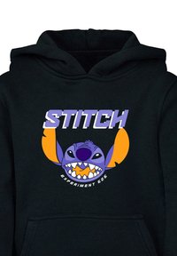 Sudadera negra con capucha que presenta un gran gráfico colorido de Stitch, un personaje morado con orejas naranjas, y el texto "STITCH" arriba en una fuente negrita.