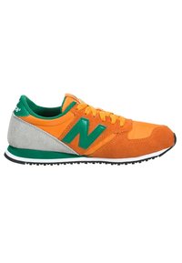 Pomarańczowe i zielone sneakersy New Balance z panelami z zamszu i tkaniny, żółtymi sznurówkami, białą i czarną podeszwą oraz szarym detalem na pięcie.