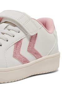 Vit sneakers med en rosa glittrande rand och rem, vilket framhäver dess sportiga design och avslappnade stil.