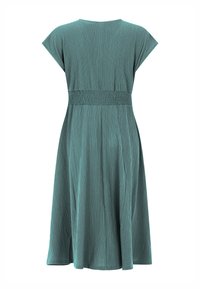 Turkooisblauwe, knielange jurk met gestructureerde stof, korte mouwen en een elastische tailleband, van achteren getoond op een witte achtergrond.