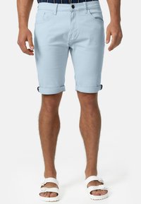 Svijetloplave kratke hlače od pamuka s glatkom teksturom, s prevrnutim donjim dijelom, dva prednja džepa i jednim stražnjim džepom.