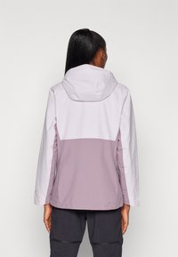 Veste légère bicolore avec une moitié inférieure violette et une moitié supérieure blanche. Elle possède une capuche et des manches longues. Texture de tissu lisse.