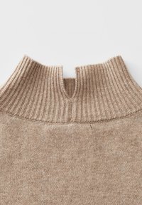 Beiger Pullover mit einem hohen gerippten Kragen im Split-Design, hergestellt aus einem weichen, strukturierten Strickstoff. Schlichte, minimalistische Ausführung.