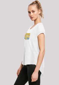 T-shirt bianco a maniche corte con una grafica colorata di "Wonder Woman", vestibilità rilassata e orlo posteriore leggermente più lungo.