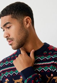 Strickpullover mit einem mehrfarbigen Fair Isle-Muster mit Hunden. Dunkelblaue Basis, rote und grüne Akzente, gerippte Bündchen und Rundhalsausschnitt.