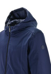 Giacca con cappuccio blu navy con chiusura a zip, texture liscia e un distintivo rotondo sulla spalla sinistra. Presenta un interno imbottito.