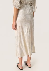 Satin midi-nederdel i lys beige med et struktureret mønster; har elastisk talje og en sideslids for bedre bevægelighed.