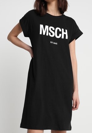 Zwarte katoenen T-shirtjurk met korte mouwen, voorzien van opvallende witte tekst "MSCH" en "EST MMX" aan de voorkant. Simpele, losse pasvorm.